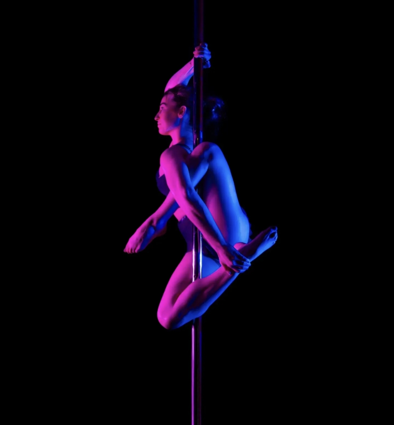 Pole dance sous lumières néon bleu et violet