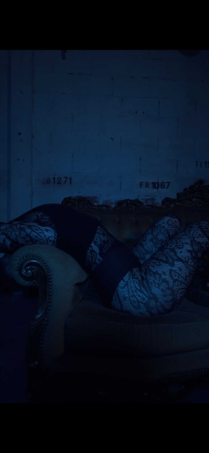 Mise en scène intime, sofa baroque, dentelle, lumière bleue