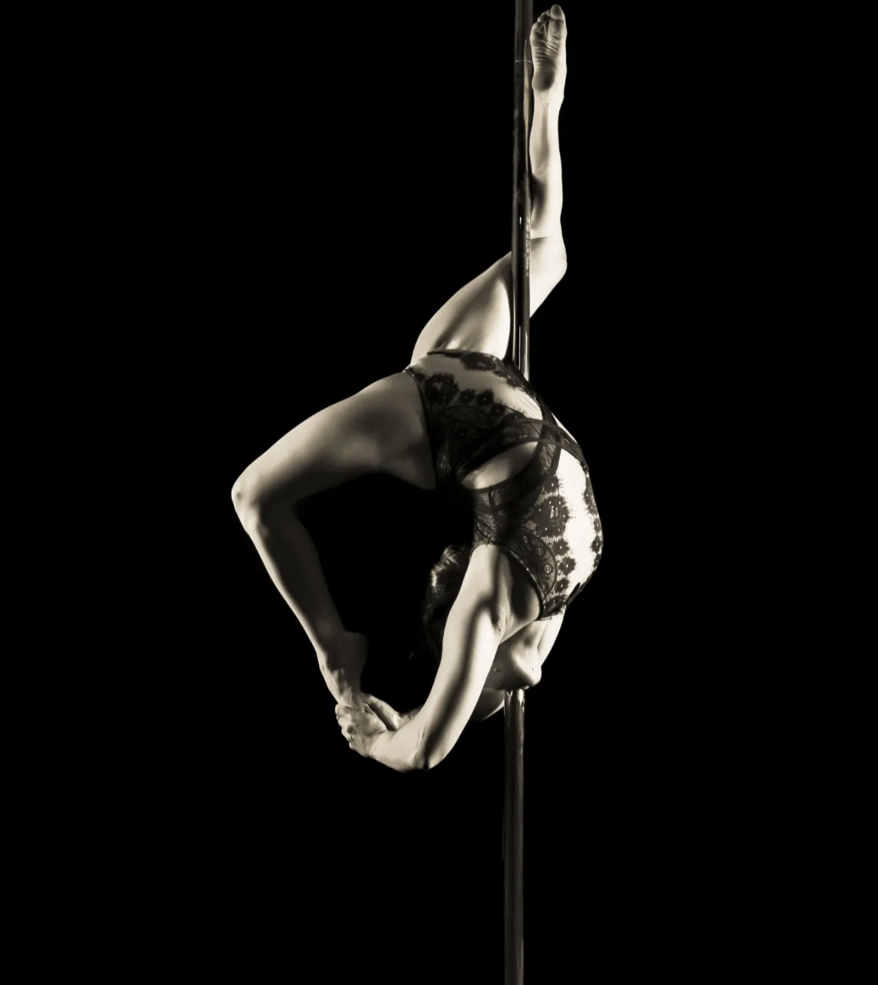 Cambré en pole dance, body en dentelle, photo noir et blanc
